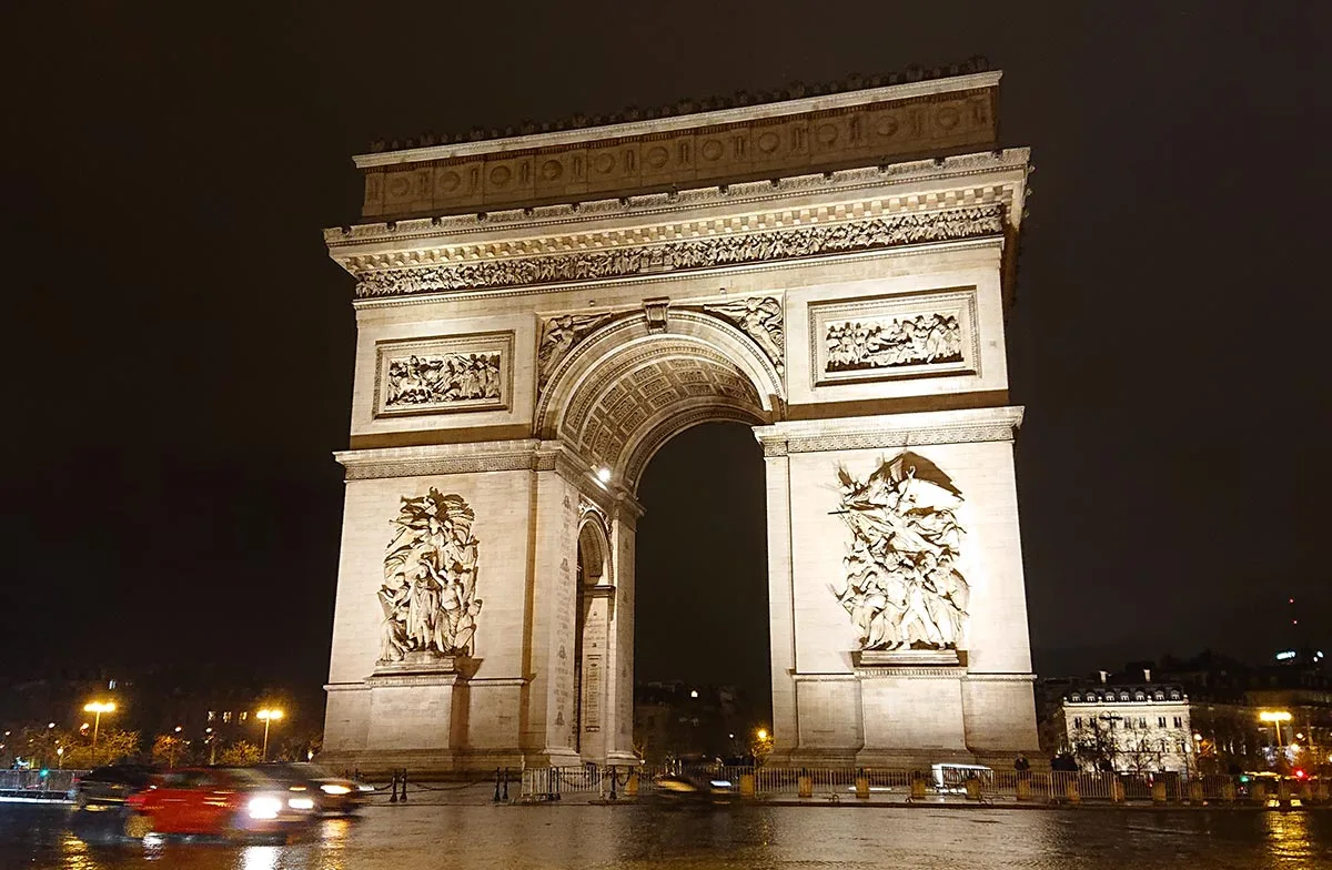 The illuminated Arc De Triomphe at night - Paris Travel Guide