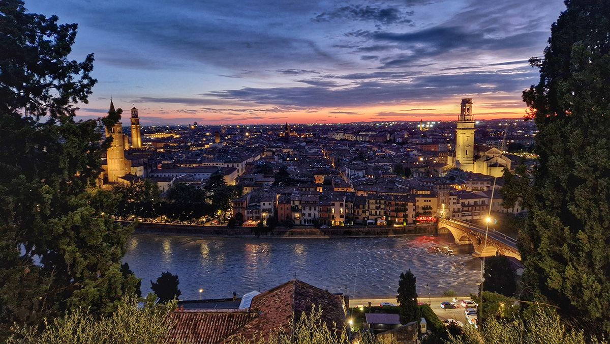 Panoramic sunset view over the red terracotta rooftops of Verona from the Castel San Pietro terrace