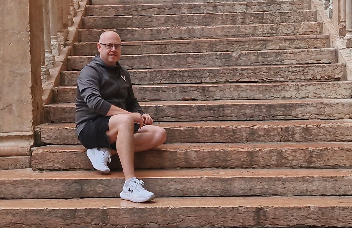 Kolyn sitting on the wide marble steps of Piazza Bra near the Verona Arena