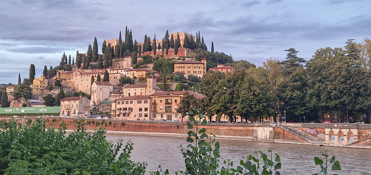 View of the historic Ponte Pietra bridge crossing the Adige River towards Castel San Pietro