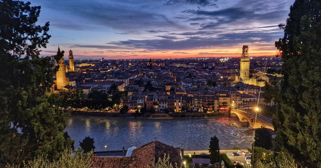 Panoramic sunset view over the red terracotta rooftops of Verona from the Castel San Pietro terrace