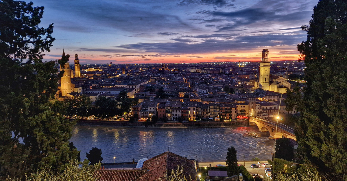 Panoramic sunset view over the red terracotta rooftops of Verona from the Castel San Pietro terrace