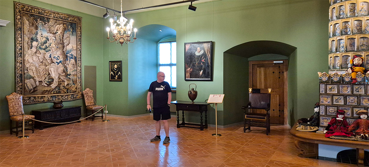 Kolyn sitting in a medieval chair inside the Renaissance Rooms at the Palace of the Grand Dukes of Lithuania